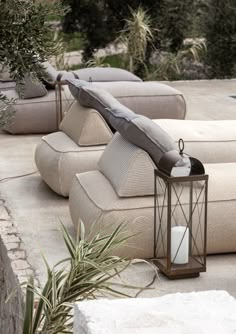 an outdoor seating area with pillows and candles