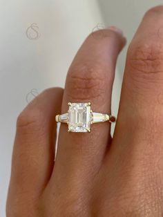 a woman's hand with an engagement ring on it