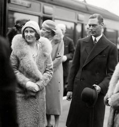 an old black and white photo of people standing on the train platform with one woman wearing a fur coat