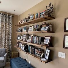 a living room filled with furniture and bookshelves next to a window covered in curtains