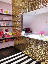 a room with gold sequins on the walls and a mirror in the corner