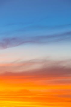 an airplane is flying in the sky at sunset or sunrise with orange and blue colors