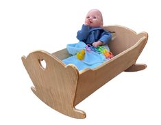 a wooden toy boat with a baby in it