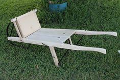 a wooden chair sitting on top of a lush green field