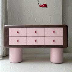 a pink dresser sitting in front of a window with a bird flying over the top