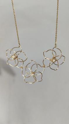 a gold necklace with flowers on it