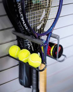 tennis rackets and balls are hanging on the wall