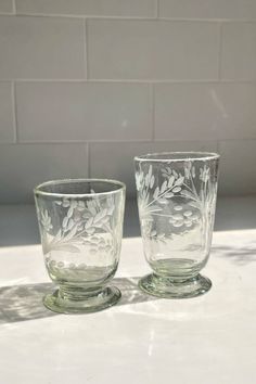 two glass cups sitting on top of a counter