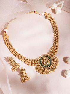 This jewellery set consists of a necklace and a pair of earringsThe gold-plated necklace has a green/red stone-studded Lakshmi motif, secured with a draw-string closureA pair of matching drop earrings, each secured with a post and back closure. Size & Fit Necklace: 21 cmEarrings: 2.5 cm Material & Care Material: BrassPlating: Gold-platedStone Type: Artificial stones Care Instruction Wipe your jewellery with a soft cloth after every useAlways store your jewellery in a flat box to avoid accidental scratchesKeep sprays and perfumes away from your jewelleryDo not soak your jewellery in waterClean your jewellery using a soft brush, dipped in jewellery cleaning solution only Dispatch within 7 days Temple Necklace, Jewelry Cleaning Solution, Artificial Stone, Stone Studs, Indo Western, Western Jewelry, Jewellery Set, Dress Jewelry, Red Stone