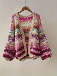 This sweater is a cozy, oversized knit cardigan with a gradient color pattern. It features a variety of pastel and muted hues, blending seamlessly from one color to the next. The color palette includes shades of pink, purple, beige, and hints of blue and green, creating a soft and dreamy appearance. The knit fabric is chunky and textured, providing warmth and a comfortable fit. The sweater has a loose, relaxed silhouette with dropped shoulders and wide sleeves, giving it an effortlessly chic and Shoulder Cardigan, Drop Shoulder Cardigan, Oversized Knit Cardigan, Oversize Knit, Cardigan Women, Rainbow Color, Knitted Cardigan, Wide Sleeves, Shades Of Pink