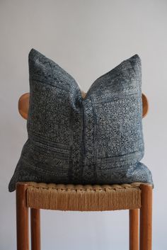 a blue pillow sitting on top of a wooden chair