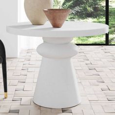 two vases sitting on top of a white table in front of a black chair