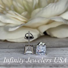 "The stud earrings pictured are simulated diamond #5036 Approximate total carat weight: approx. 2.00ctw diamond equivalent -Center Stone Size: 6x6mm - approx. 1.00ct each diamond equivalent -Center Stone Shape: radiant cut -Gem Type: simulated diamond -Stone Clarity: VVS1 -Stone Color: D -Moh's Scale: 8.5 hardness -Metal Type and Purity: 14k white gold -Setting: 4 prong basket head -Backing: friction back (earring backs are subject to change due to availability) -Country of Manufacturing: USA (M Oval Diamond Bridal Earrings For Anniversary, Diamond White Earrings With Prong Setting As Gift, Gift Earrings With Prong Set Lab Grown Diamonds, Gift Earrings With Lab Grown Diamonds And Prong Setting, Emerald Cut Lab Grown Diamond Jewelry For Anniversary, Oval Bridal Earrings For Anniversary In Fine Jewelry Style, Radiant Cut Moissanite Jewelry For Anniversary, Lab Grown Diamond Earrings With Diamond Accents Gift, Elegant Asscher Cut Diamond Earrings For Anniversary