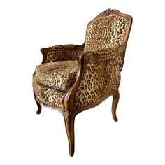 the leopard print chair is upholstered with wood trimming and an ornate arm rest