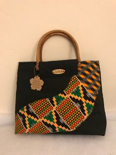 African Kente Handbag/Purse. Elegant and stylish. African Fabric/Multi Colored Bag with bamboo/cane handles.  Handles may vary and subject to availability. Handles may come in bamboo, clear or any other color. Pattern on fabric may also vary  Size is approximately 16.5 (L) x 11 inches (H) X 3.5 (W) Ankara Handbags Kitenge, Handmade Black Tote Bag, Handmade Black Satchel For Shopping, Traditional Black Shoulder Bag Gift, Traditional Black Shoulder Bag As Gift, Traditional Black Shoulder Bag For Gift, Black Tote Hobo Bag For Gift, Traditional Black Pouch Bag, Handmade Black Bag As Gift