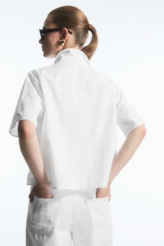 Everyday Cotton Blouse With Roll-up Sleeves, Summer Cotton Short Sleeve Shirt With Placket, Cotton Shirt With Roll-up Sleeves And Shirttail Hem, White Tops With Roll-up Sleeves For Everyday, White Short Sleeve Shirt With Camp Collar For Spring, Cotton Shirt For Spring Daywear, Cotton Blouse With Rolled Sleeves For Daywear, Cotton Daywear Blouse With Rolled Sleeves, Relaxed Fit Cotton Top With Placket