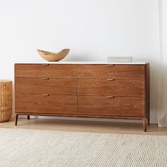 a wooden dresser with a bowl on top of it