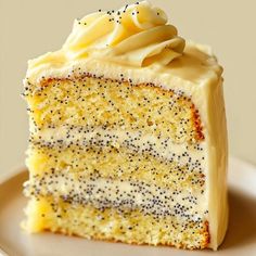 a slice of cake with white frosting and black sprinkles on it