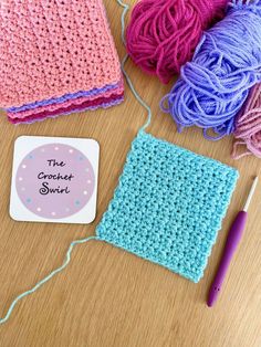 the crochet dishcloth is next to a ball of yarn and a knitting needle