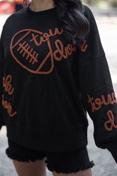 Black terry knit pullover accented with embroidered footballs and 'touchdown' In the Fall we are all Touchdown Obsessed!! Show your gameday spirit in this fabulous black sweatshirt, featuring brown embroidery braided footballs and the word 'touchdown' on the front and down the sleeves. With a crew neckline and long balloon sleeves, she's as comfy as she is festive. Tailgating never looked so stylish! True to size fit; relaxed silhouette Model is 5'5" wearing a small Fabric contains stretch Ribbe Football Party Outfit, Tailgating Outfits, Shoulder Embroidery, Brown Embroidery, Tailgate Outfit, Graphic Tee Dress, Football Sweatshirt, Football Party, Vintage Couture