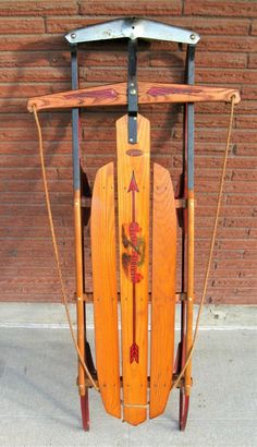 an old fashioned wooden sled sitting on the sidewalk