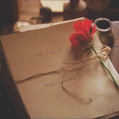 a red flower is tied to an old book