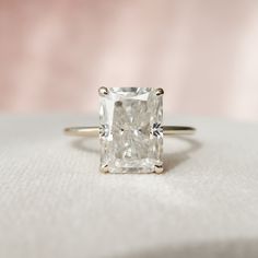 a diamond ring sitting on top of a white cloth