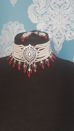 Beautiful pearl choker with matching earrings . Absolutely stunning pieces of jewelry.  Set includes ten strand choker necklace and matching earrings. Silver plated.  Ruby pink stones and beads have been added to finish the look. The set is traditional Hyderabadi design.  Picture do not do justice to the actual set.  Please make sure you have read our shop policies before making a purchase.  Thanks Elegant Festive Pearl Choker Necklace, Silver Pearl Jewelry Sets For Festivals, Traditional Pearl Drop Choker Necklace, Wedding Temple Jewelry Pearl Choker Necklace, Elegant Pearl Choker For Festivals, Elegant Wedding Choker For Festivals, Traditional Pearl Choker Necklace For Wedding, Elegant White Chandbali Choker, Silver Bridal Necklace With Pearl Drop For Festivals