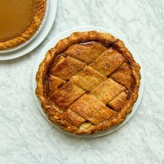 two pies sitting on top of a table next to each other with one slice cut out