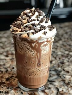 there is a chocolate milkshake with whipped cream and chocolate chips on the top