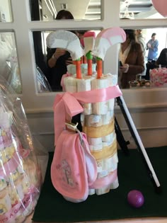 a stack of diapers and golf balls in front of a window at a baby shower