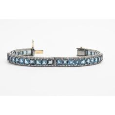 Pair of London blue topaz and diamond bangles mounted in sterling silver with a 14k gold tongue clasp and safety. Each bracelet contains princess cut blue topaz prong set down the center with round diamonds along the side edges.  The 2 bracelets have a combined carat weight of 5.28 carats in diamonds and 61.23 in London blue topaz.  Internal circumference is 7.12".  across inside 2 3/8" by 2 5/16" Exquisite Blue Jewelry With Single Cut Diamonds, Diamond Bracelets With Gemstone Accents For Anniversary, Classic Blue Topaz Jewelry With Diamond Accents, Elegant White Gold Bracelet With Blue Topaz, Blue Topaz Gemstone Bangle Jewelry, Elegant Blue Topaz Bangle Jewelry, Fine Jewelry Blue Topaz Bracelets, Blue Topaz Gemstone Bracelets For Wedding, Sterling Silver Gemstone Bracelet