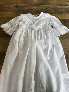 A beautiful vintage baby's Christening robe made by Sturgenegger, Switzerland.  100% Baumwolle, high quality cotton. It has a small collar, lace and appliqué puffed sleeves.  It has a cotton lining. Three buttons at the back.  Lace and appliqué front and hem.  Length 81cm Chest 25 cm  It is bright white and is in lovely condition. Fitted Embroidered Baptism Dress For Spring, Spring Baptism Dress Embroidered And Fitted, Spring Embroidered Fitted Baptism Dress, Fitted Embroidered Spring Baptism Dress, Long Sleeve Baptism Dress With Ruffles For First Communion, Long Sleeve Baptism Dress With Ruffles, Fitted Baptism Dress With Embroidered Short Sleeves, Classic Baptism Dress With Lace Trim, Embroidered Long Sleeve Baptism Dress