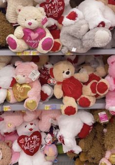 two rows of valentine's day teddy bears for sale in a store aisle with hearts on them