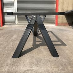 a black table sitting on top of a cement floor in front of a garage door