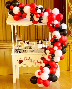 the balloon arch is decorated with black, white and red balloons