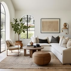 a living room filled with furniture and large windows