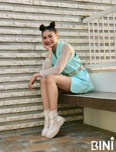 a woman sitting on top of a wooden bench