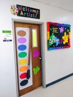 the door to an art room is decorated in bright colors and has a welcome sign on it