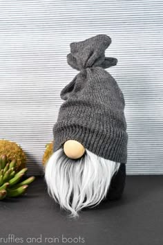 Vertical image of a black sock gnome with faux fur beard in gray with a sweater sleeve hat in gray. Adult Gnome Hat Pattern, Free Printable Gnome Hat Patterns, Diy Large Gnomes How To Make, How To Make A Gnome Hat, Gnome Hat Patterns, Diy Gnome Hat, Gnome Hats Diy Free Pattern, Free Gnome Patterns, Gnome Hat Pattern