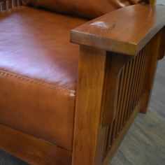 a brown leather chair sitting on top of a hard wood floor