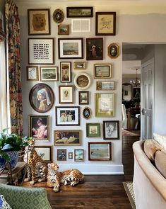 a living room filled with lots of pictures on the wall