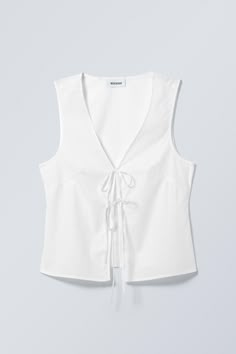 A slim fit vest top crafted from a crisp plain cotton. It has a V-neckline, a double tie front closure, darts at the bust and in the back for added structure and falls at the hips. Vest Top Pattern, Gem Dress, White Vest Top, Fitted Vest, White Vest, Trending Sunglasses, Beauty Clothes, Vest White