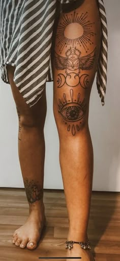 a person standing on top of a wooden floor with tattoos on their legs and feet