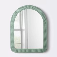 a mirror that is on the wall next to a window