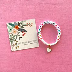 This colorful heart bracelet makes a great birthday gift! The white beads and heart charm make the heart beads pop! Personalize this bracelet for someone you love ❤️ The bracelets are beautifully packaged and ready to gift. Receipts are never included in your package. If you want to include a special note, please let me know in the comments. Roll, don't pull. To avoid excess stretching please roll the bracelet on and off. Treat and store the bracelets gently. Sizing options are just a guideline. Heart-shaped Letter Beads Bracelet For Birthday, Valentine's Day Heart Bracelet With Letter Beads For Friendship, Cute Heart Bracelet With Letter And Round Beads, Valentine's Day Heart Charm Bracelet With Letter Beads, Cute Heart Bracelet With Letter Beads, Cute Heart-shaped Bracelets With Letter Beads, Heart-shaped Valentine's Day Charm Bracelet With Letter Beads, Cute Heart-shaped Bracelet With Letter Beads, Valentine's Day Heart-shaped Charm Bracelet With Letter Beads