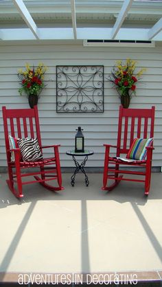 two red rocking chairs sitting on top of a patio