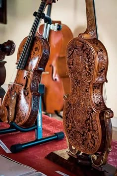 an old violin is on display in front of other musical instruments, including one that has been carved from wood