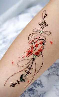 a woman's arm with red ink on it and an artistic tattoo design in the center