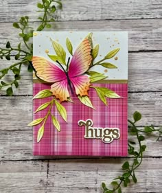 a pink card with a butterfly on it and the word hugs written in large letters